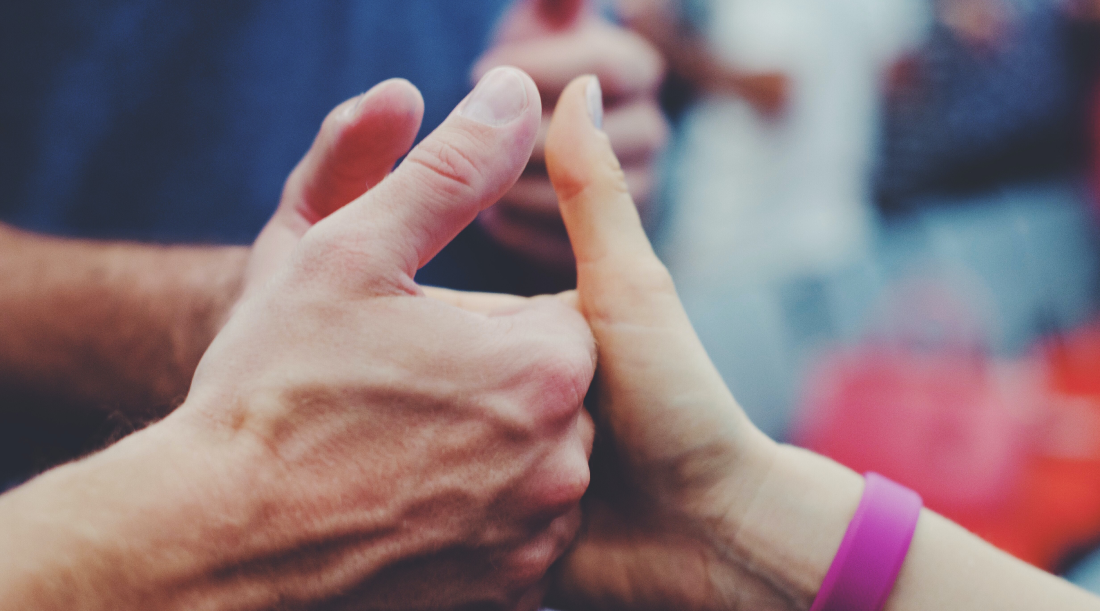 Three hands posing a thumbs up