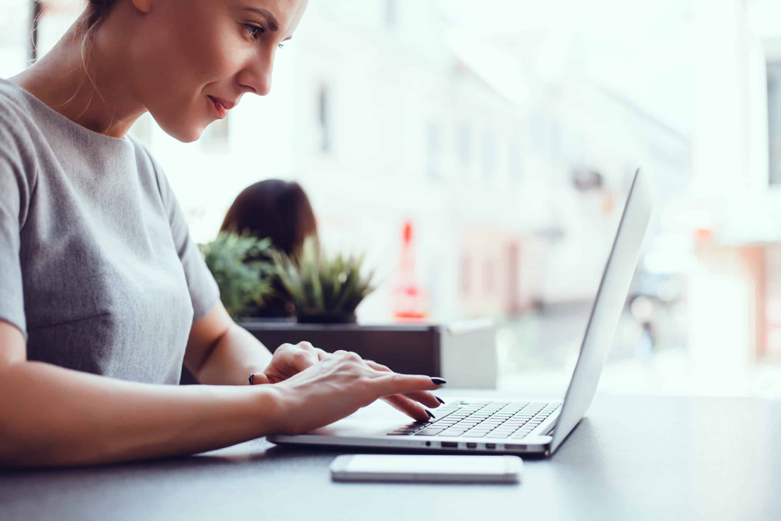 Woman using laptop in a cafe